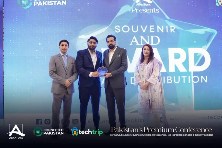 Alizaib Hassan accepting the Connected Pakistan 30 Under 30 trophy on stage